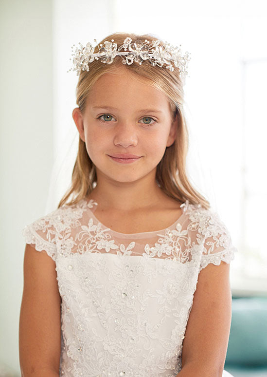 This elegant dress features a sophisticated illusion neckline adorned with delicate lace appliqué and sparkling rhinestones, creating a refined bodice perfect for flower girls and milestone celebrations