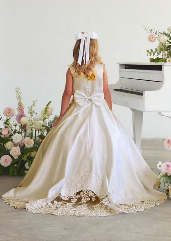 This refined toddler and girls satin gown crafted for young ladies, showcasing an ornate lace appliqué bodice paired with an elegant train embellished in delicate lace. Ivory